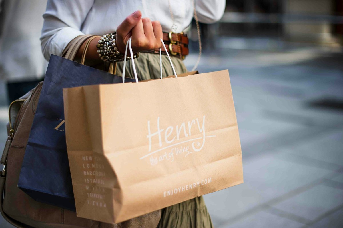 A customer leaving a shop carrying paper bags